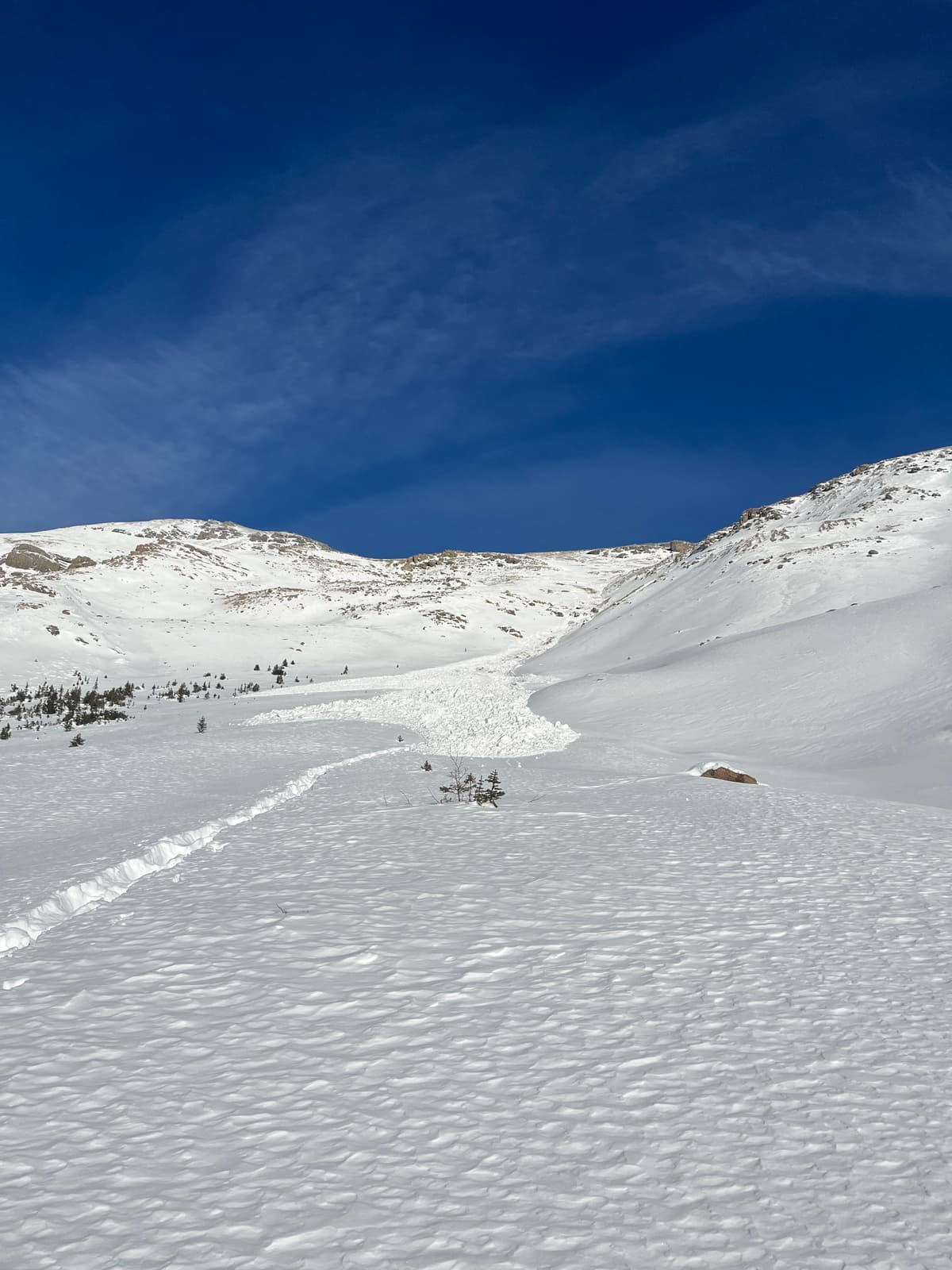 Recreational party triggered a small hard slab at the top of a steep rocky chute. Scrubbed to ground in the track and became a small size two. One of the group seemed to lose a ski.  Observed the party of two on our ascent up the mellow benched terrain and came across the tracks on our exit in the afternoon. Not a great terrain choice given the current conditions and recent feedback to skier traffic in similar terrain in very close proximity. These two are very lucky to only lose a ski given the huge jaggered rocks they went for a ride in. 