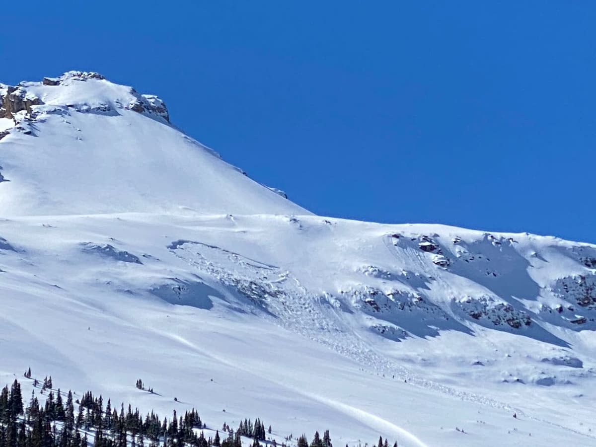 Remotely skier triggered size 2 slab from shallow snowpack area 100m away while traveling on the bench above