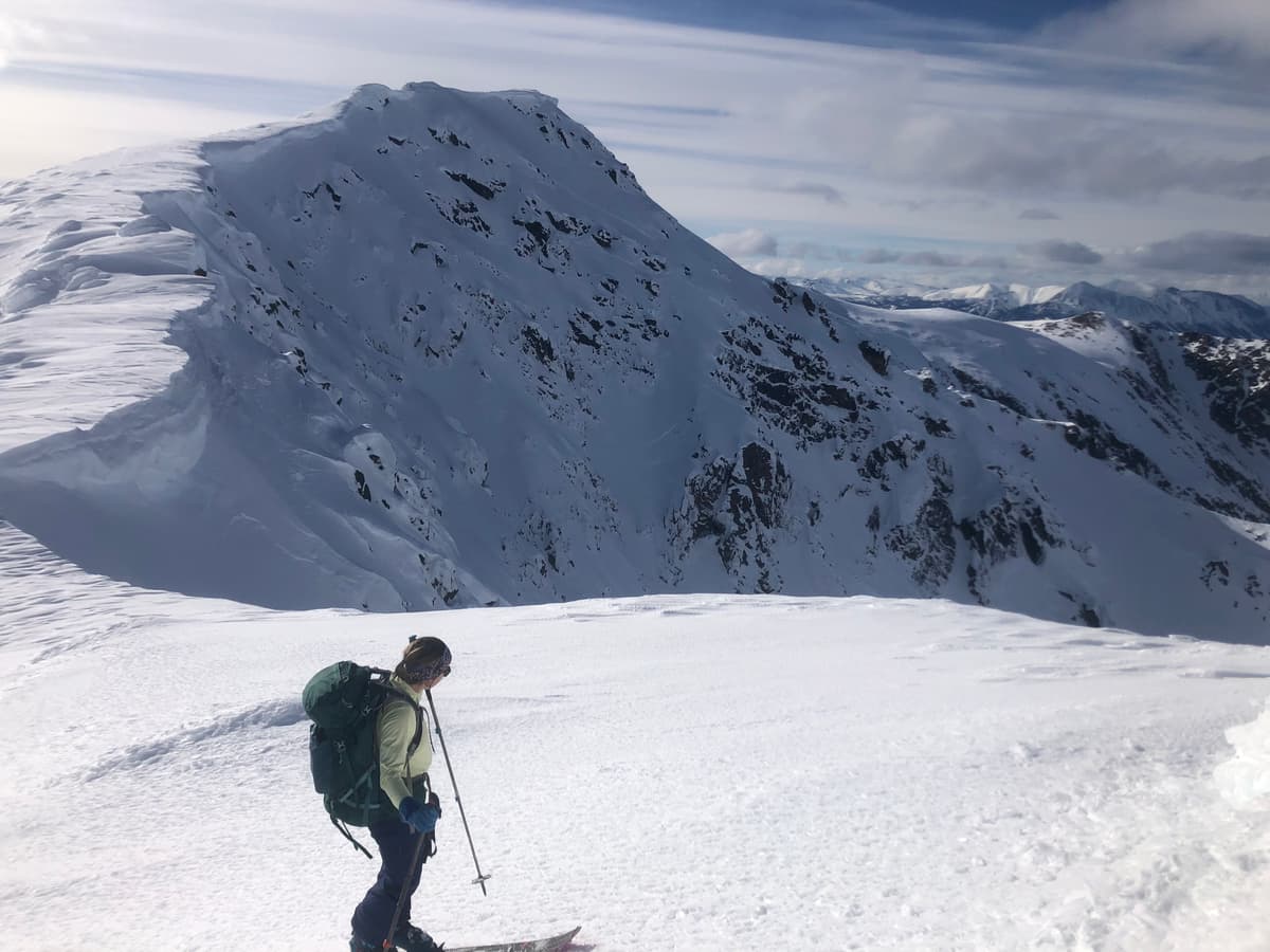 Multiple natural avalanche crown lines on the north face directly behind the cabin.