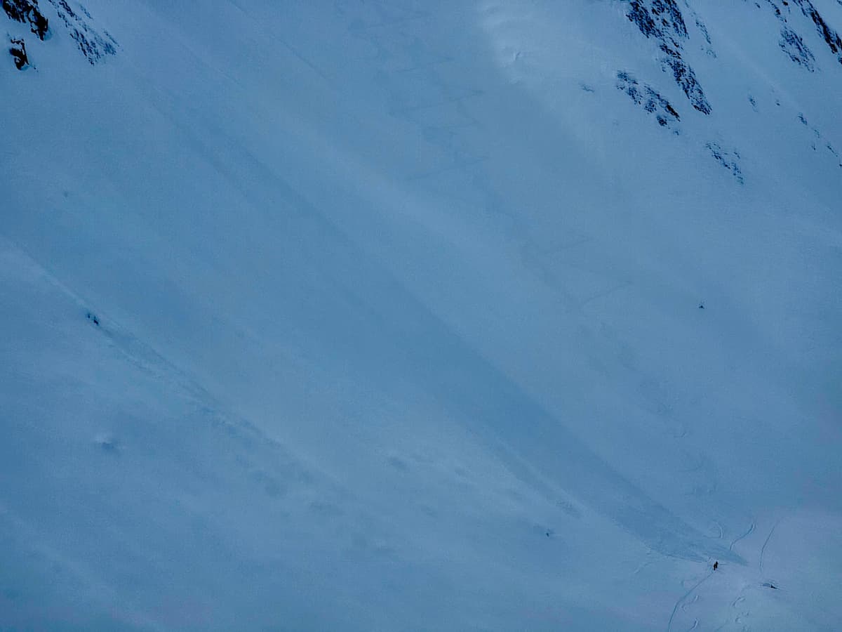 Sluff/loose dry debris. Two skiers are at the base.
