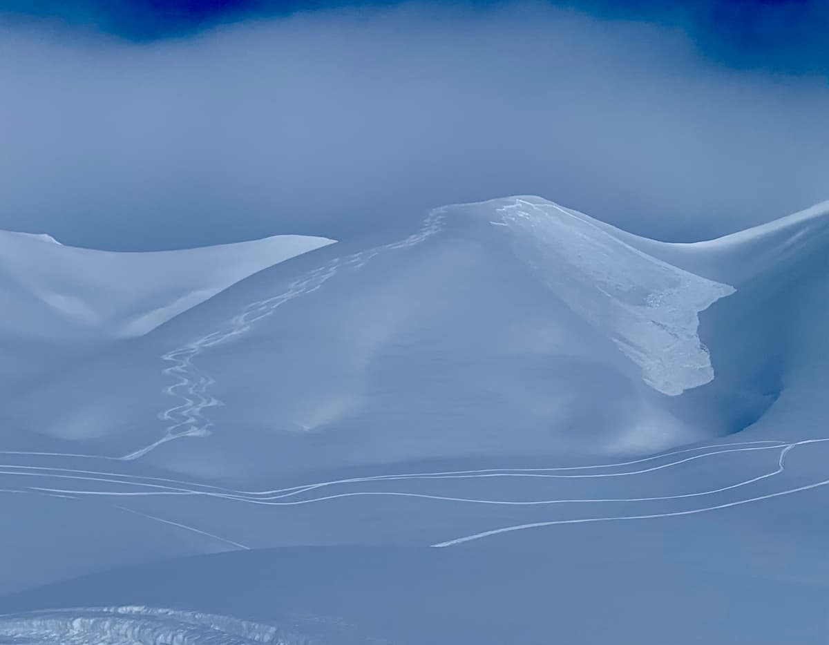 Snowboard tracks visible on the left with remotely trigger slab avalanche on the right.