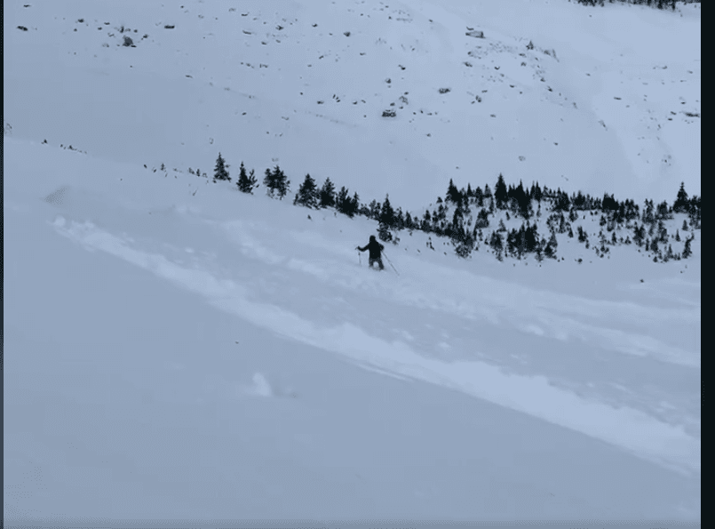 Slide begins-skier attempting to ski out of slide 