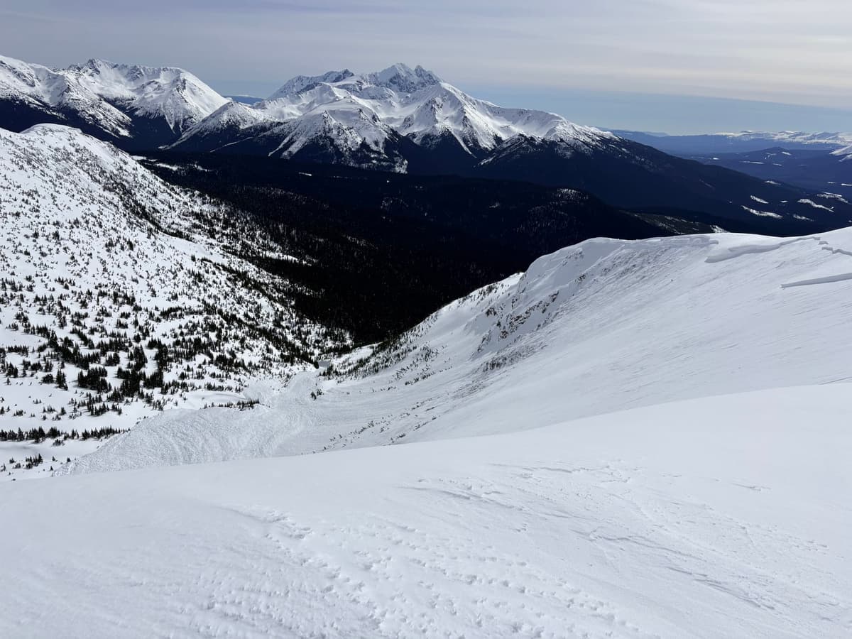 Snow accumulated at the bottom against and over a ridge. Our guess is 40-50 ft deep
